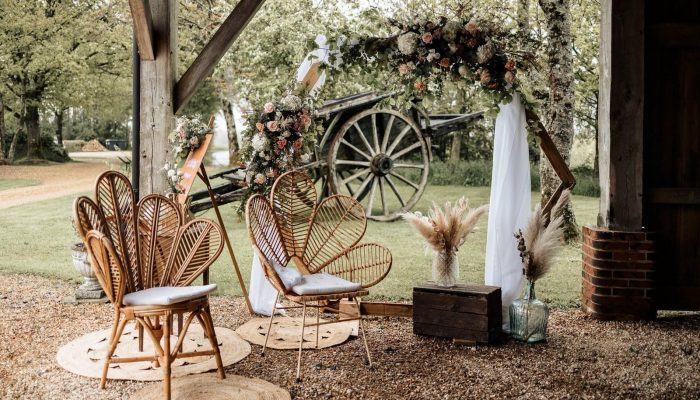 Coin-mariés-cérémonie-fauteuils-en-rotin-tulipe-fauteuil-fleur-tapis-en-jute-caisse-arche-en-bois